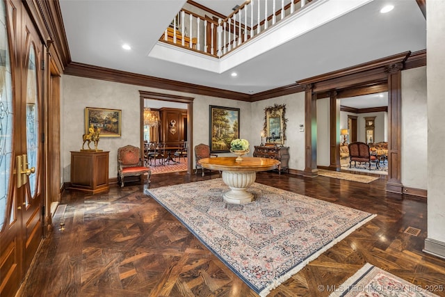 interior space with ornamental molding, baseboards, a towering ceiling, and ornate columns