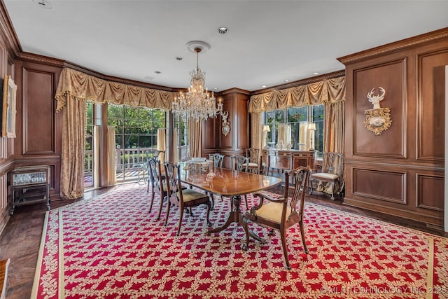 dining space with ornamental molding, plenty of natural light, and an inviting chandelier