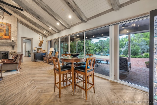 dining space featuring high vaulted ceiling, beamed ceiling, and a fireplace