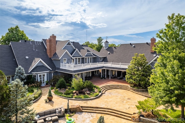 rear view of property featuring french doors, a patio, and a chimney