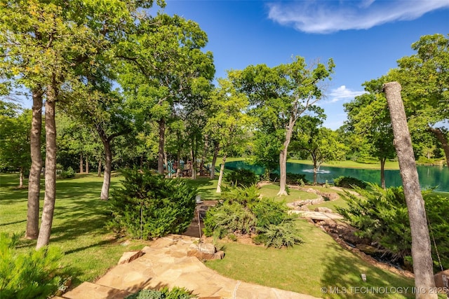 view of property's community with a water view and a yard