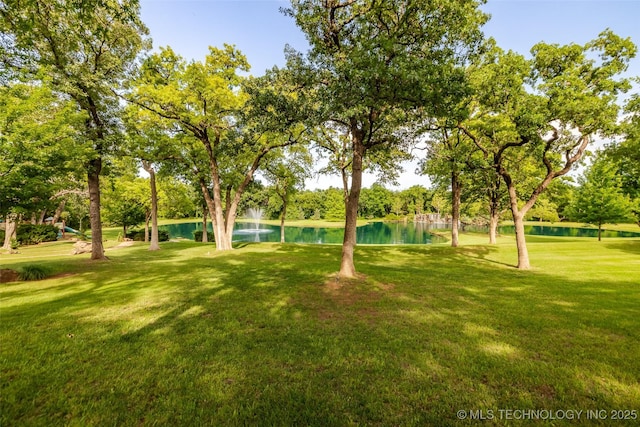 view of property's community featuring a lawn and a water view