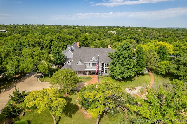 birds eye view of property featuring a forest view