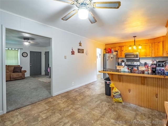 kitchen with a breakfast bar area, crown molding, pendant lighting, ceiling fan, and stainless steel appliances