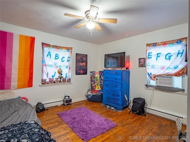 bedroom featuring cooling unit, a baseboard heating unit, hardwood / wood-style flooring, and ceiling fan