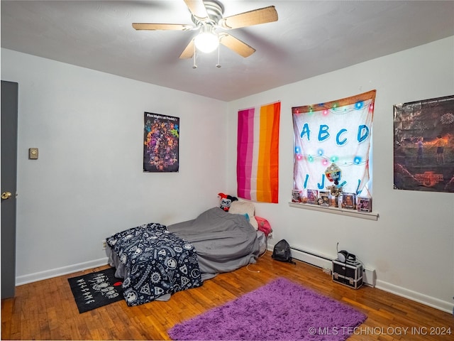 bedroom with ceiling fan, a baseboard radiator, and hardwood / wood-style floors