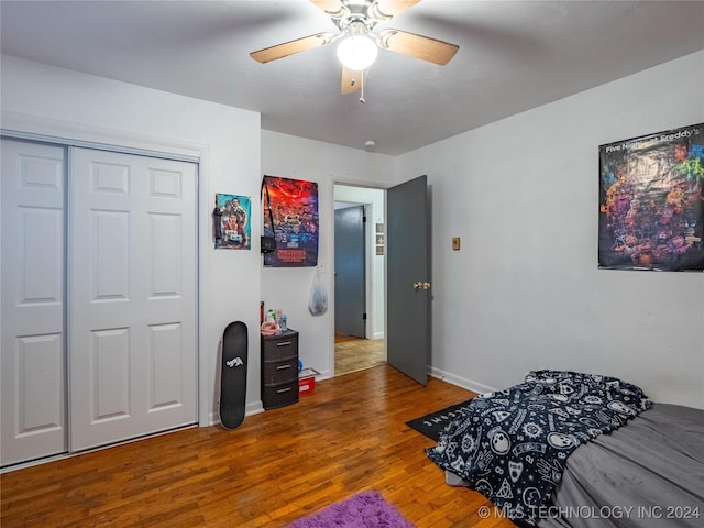 bedroom with hardwood / wood-style flooring, ceiling fan, and a closet