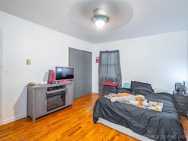 bedroom with a closet, ceiling fan, and light hardwood / wood-style flooring