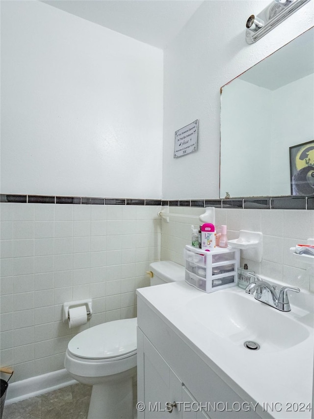 bathroom featuring vanity, tile patterned floors, tile walls, and toilet