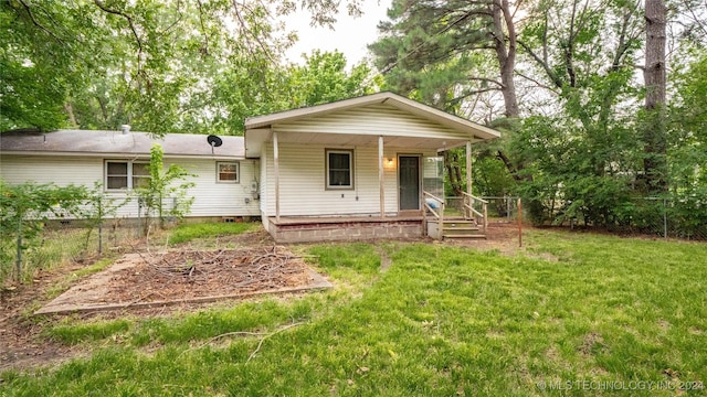 rear view of property with covered porch and a lawn