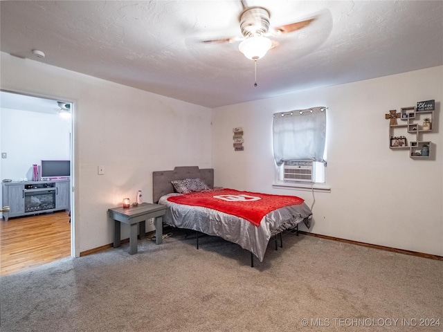 bedroom with cooling unit, a textured ceiling, ceiling fan, and carpet