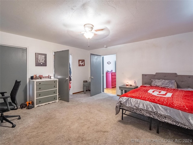 carpeted bedroom featuring ceiling fan and a textured ceiling