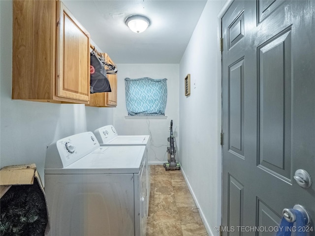 clothes washing area featuring cabinets and separate washer and dryer