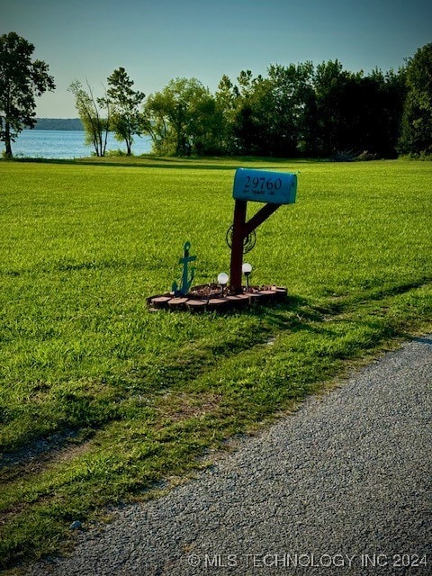 view of property's community with a lawn and a water view