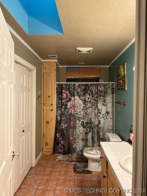 bathroom featuring a textured ceiling, crown molding, toilet, tile patterned floors, and vanity