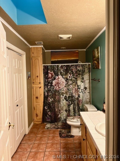 bathroom with a textured ceiling, toilet, crown molding, tile patterned floors, and vanity