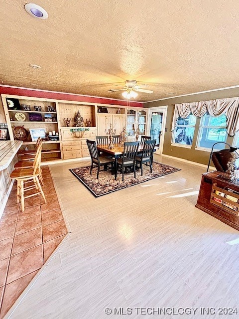 dining room featuring a textured ceiling, tile patterned flooring, and ceiling fan