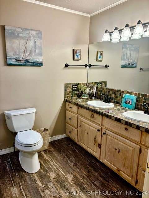 bathroom featuring toilet, tasteful backsplash, ornamental molding, hardwood / wood-style flooring, and dual vanity