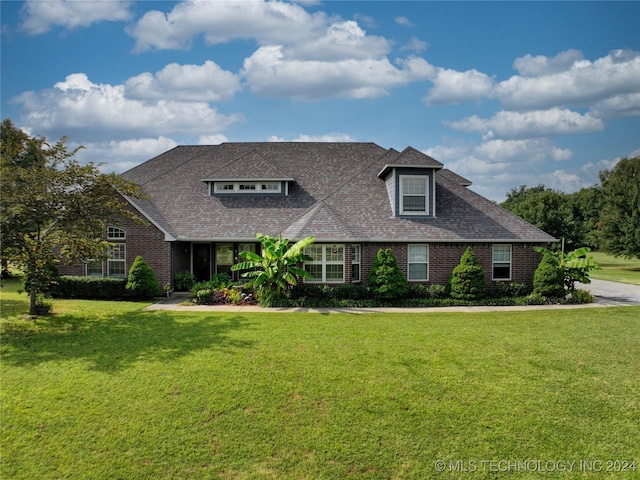 view of front facade featuring brick siding and a front yard