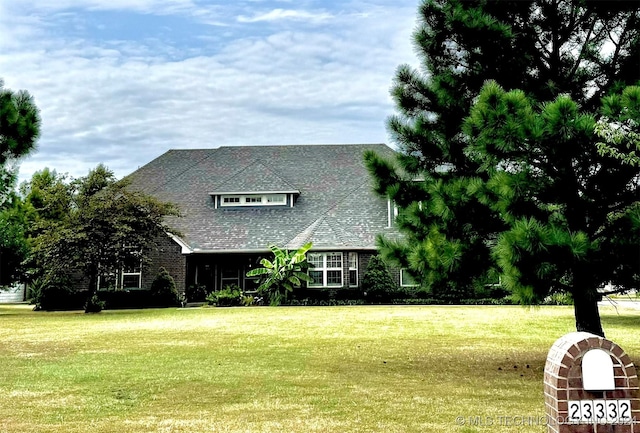 view of front of home with a front lawn and roof with shingles