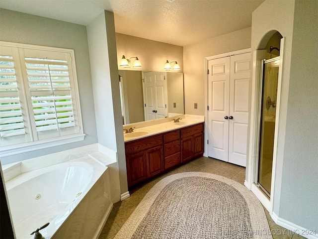 full bath with a whirlpool tub, double vanity, a stall shower, and a sink