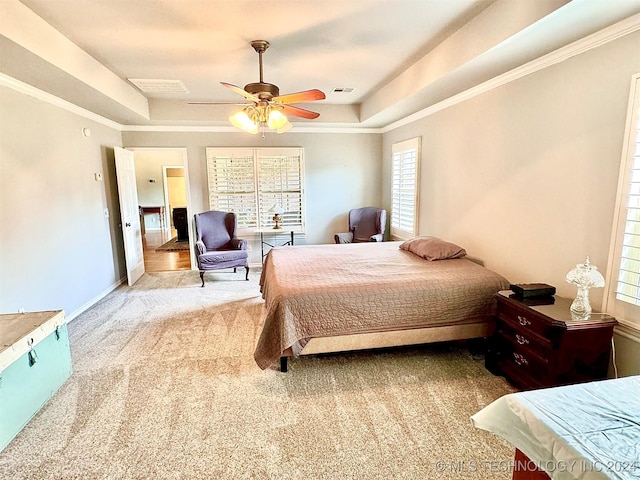 carpeted bedroom featuring a raised ceiling, visible vents, ornamental molding, a ceiling fan, and baseboards