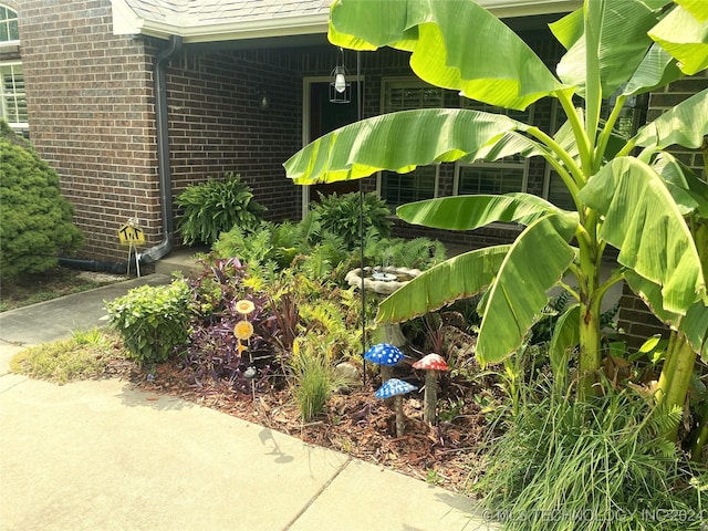 exterior details with gutters, a downspout, and brick siding