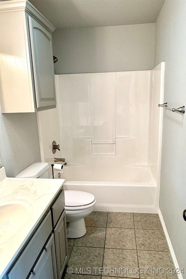 bathroom with bathtub / shower combination, toilet, vanity, tile patterned flooring, and baseboards