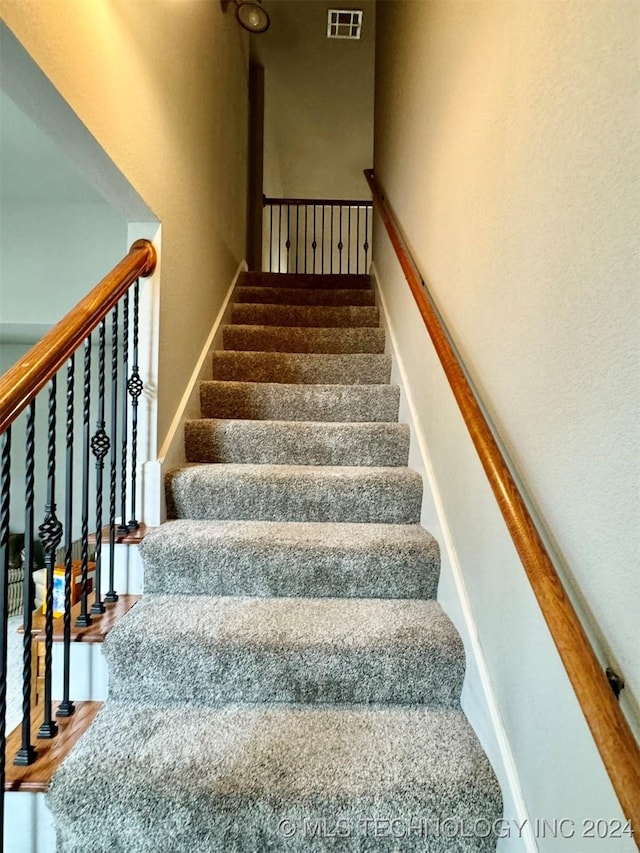 stairs featuring wood finished floors and visible vents