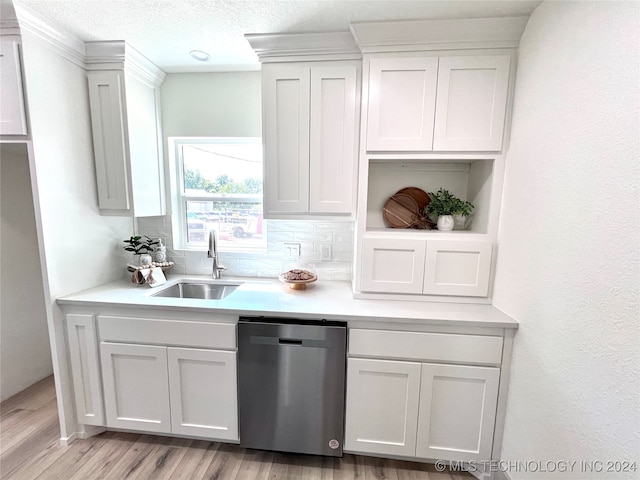 kitchen with light wood-type flooring, tasteful backsplash, sink, and dishwasher