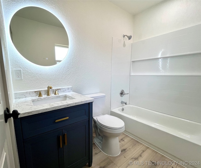 full bathroom featuring vanity, toilet, hardwood / wood-style floors, and shower / washtub combination