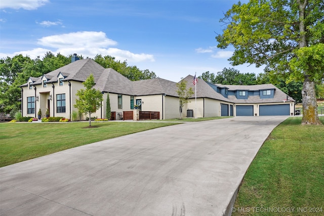 french country home with a garage and a front lawn