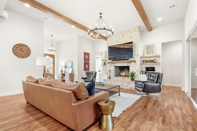 living room featuring beam ceiling, a fireplace, and light hardwood / wood-style floors