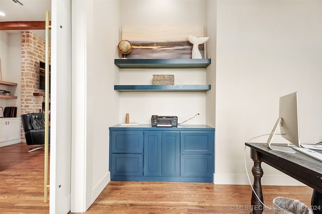 interior space with brick wall and light hardwood / wood-style floors