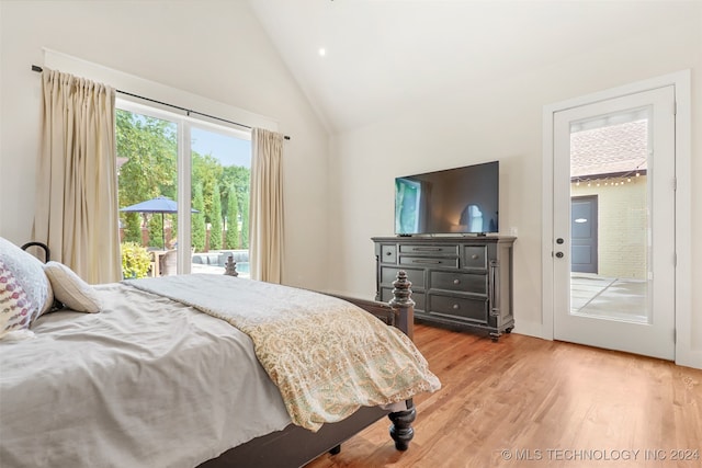 bedroom with high vaulted ceiling, access to outside, and hardwood / wood-style flooring