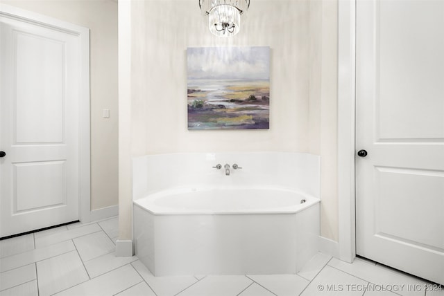 bathroom with a notable chandelier, a bathtub, and tile patterned floors