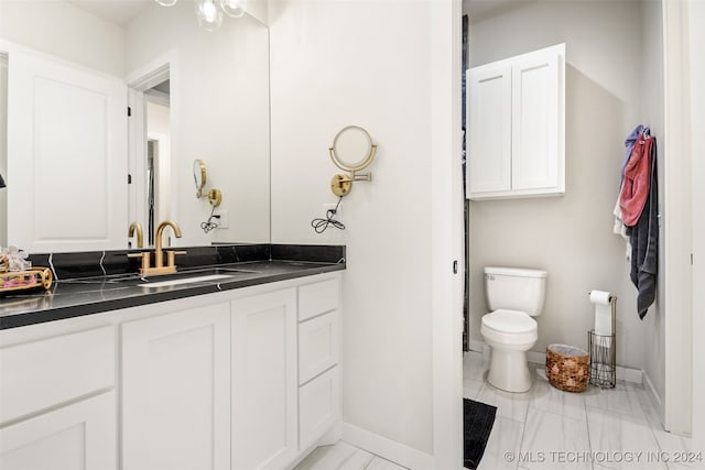 bathroom featuring vanity, toilet, and tile patterned flooring