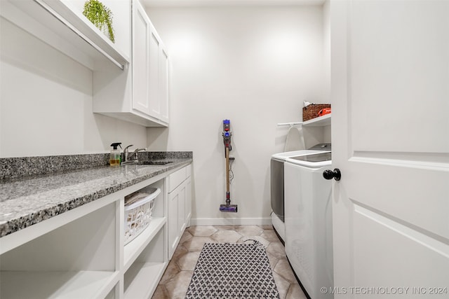 clothes washing area featuring sink, washing machine and clothes dryer, cabinets, and light tile patterned floors