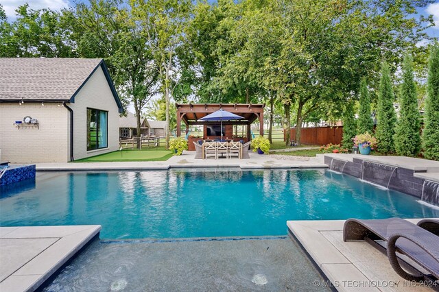 view of pool with a patio area, pool water feature, and a gazebo