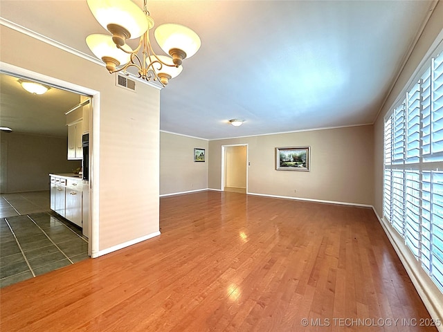 empty room with dark wood-type flooring, an inviting chandelier, and crown molding