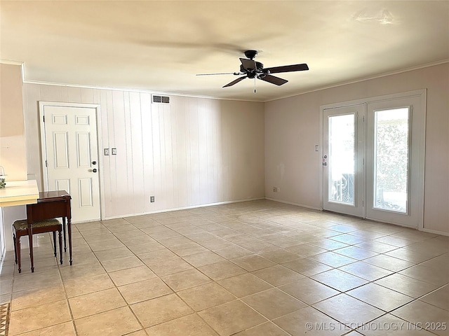 spare room featuring ceiling fan, light tile patterned floors, and ornamental molding