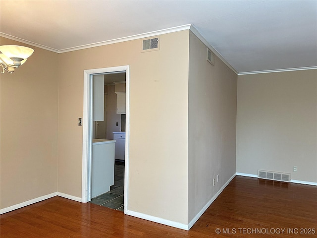 empty room featuring ornamental molding and dark hardwood / wood-style floors