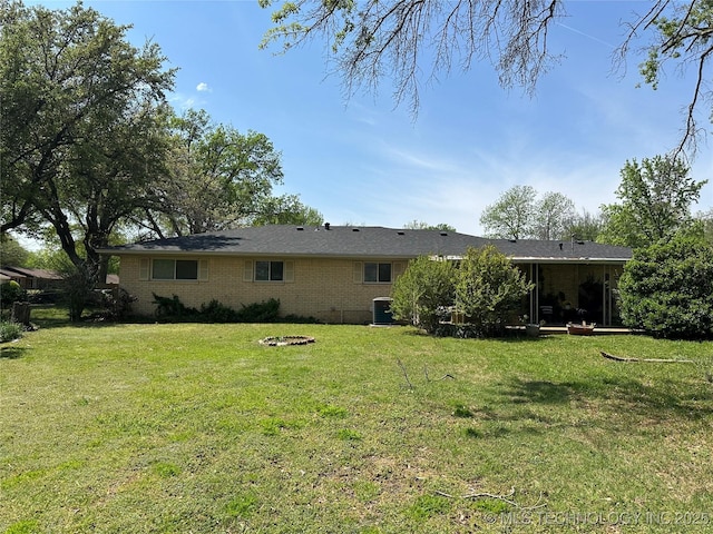 814 Pershing E, Ardmore, OK 73401 - back of house with brick siding, cooling unit, and a lawn