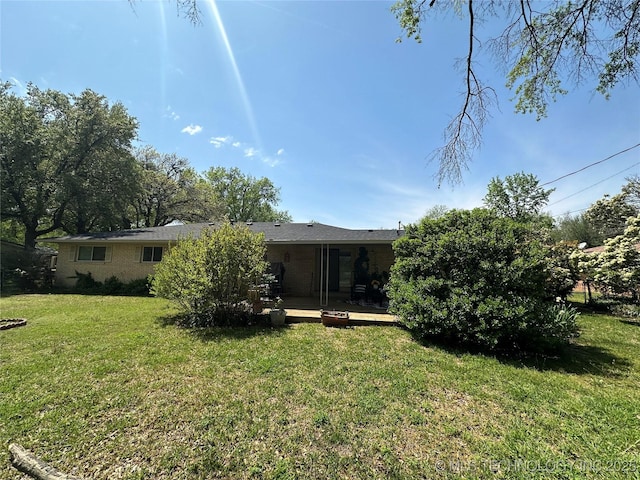 814 Pershing E, Ardmore, OK 73401 - rear view of property with brick siding and a lawn
