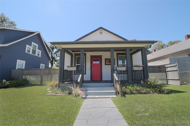 bungalow with a front yard and covered porch