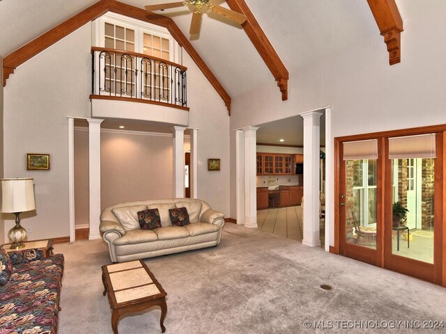 carpeted living room featuring beam ceiling, ceiling fan, high vaulted ceiling, and ornate columns