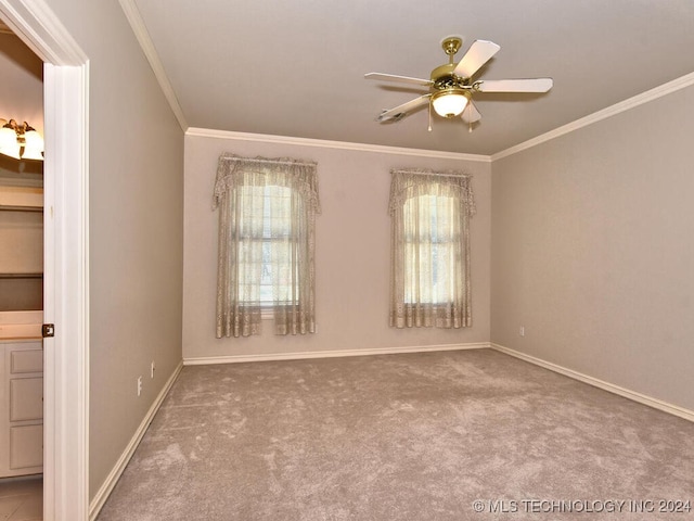 carpeted spare room with ceiling fan and crown molding