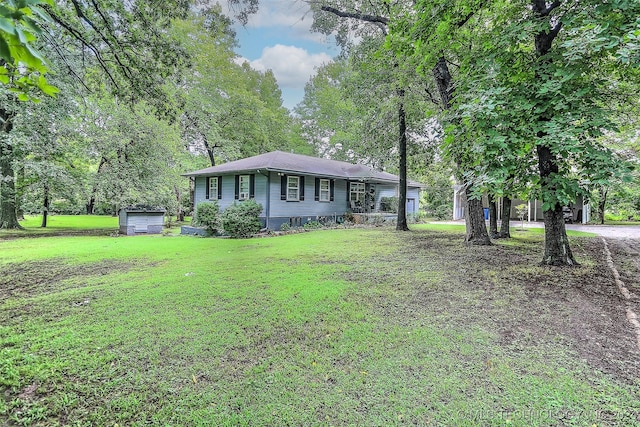 single story home featuring a front lawn and an outbuilding