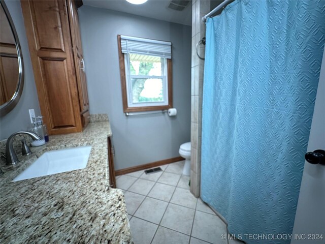 bathroom featuring toilet, vanity, and tile patterned flooring