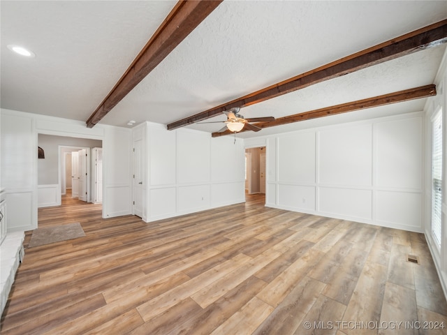 unfurnished living room with ceiling fan, beam ceiling, light hardwood / wood-style floors, and a textured ceiling